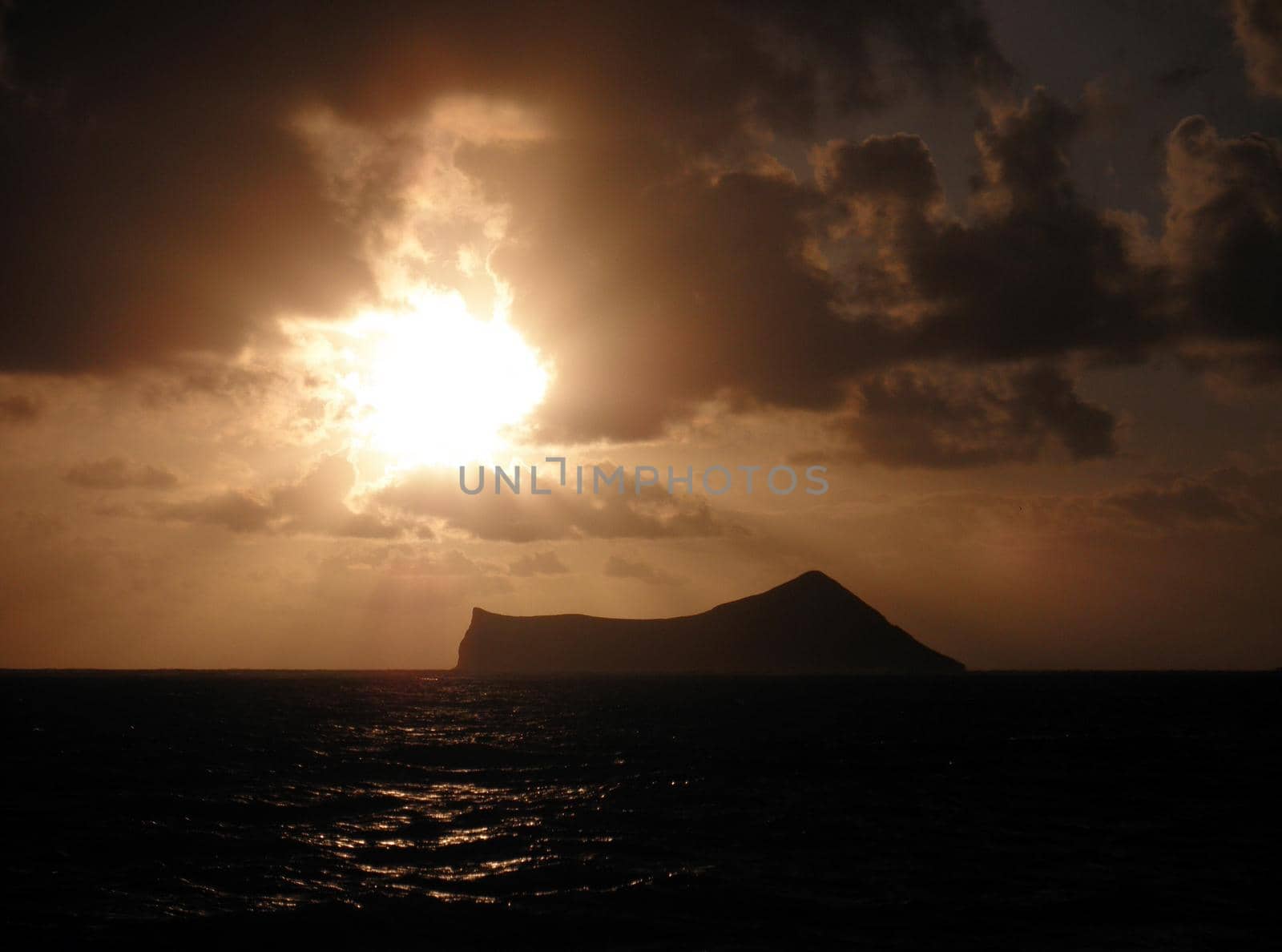 Sunrise through clouds over Rabbit Island in Waimanalo Bay on Oahu, Hawaii