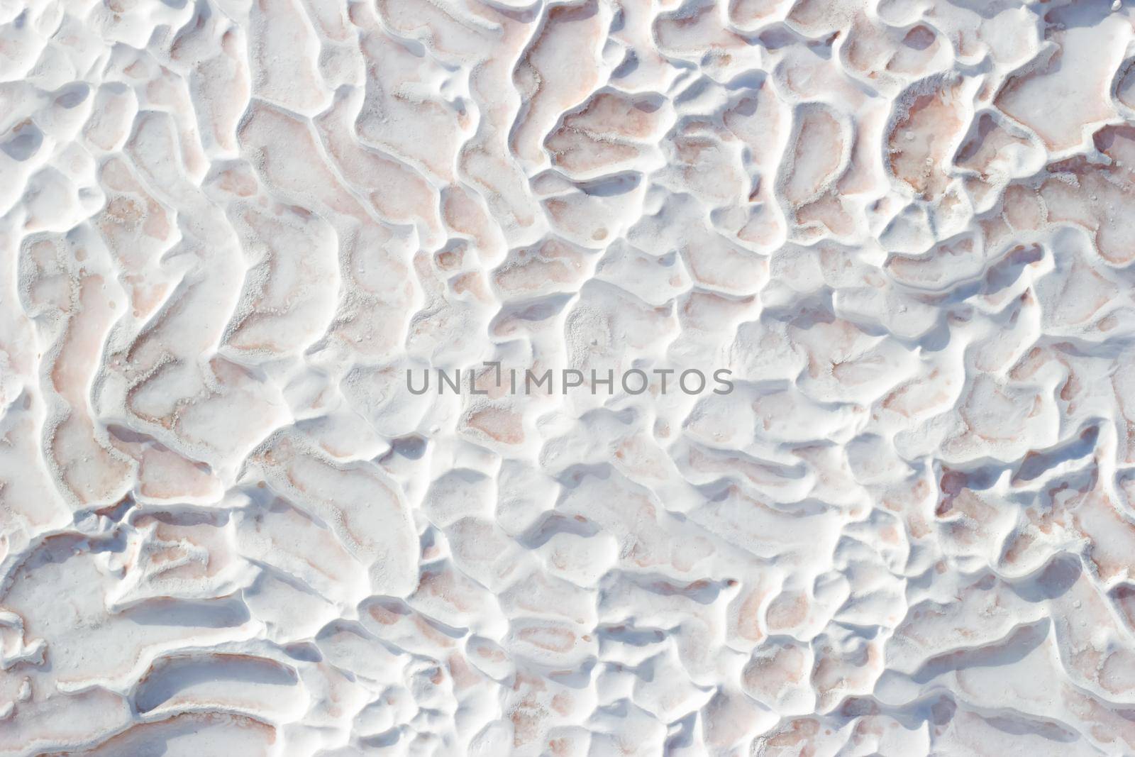 Background white texture of Pamukkale calcium travertine in Turkey, abstract pattern, top view.