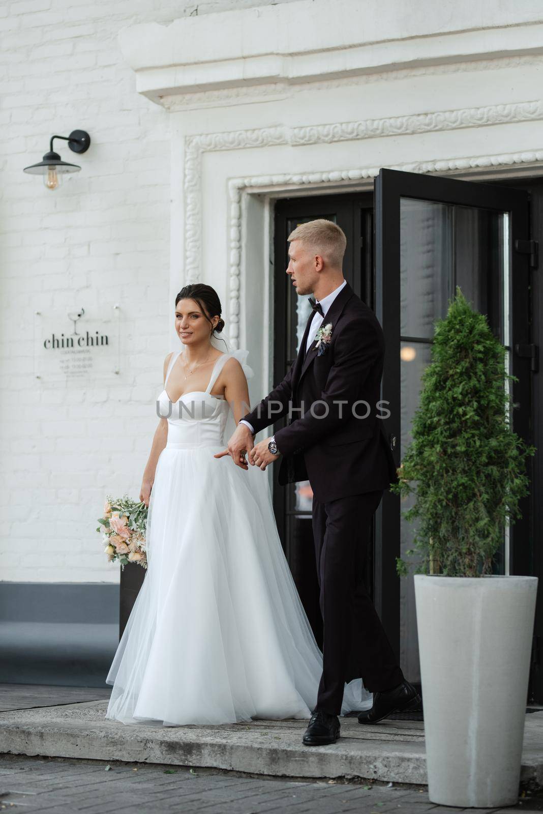 bride and groom near the cafe on the street of the summer city