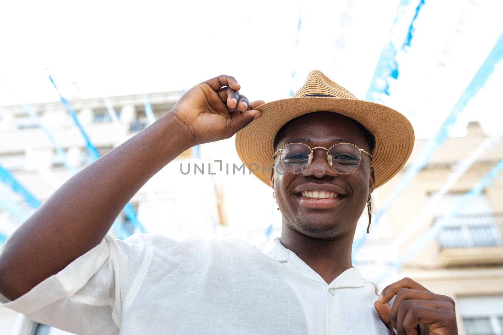 Happy black man wearing a hat smiling looking at camera during holidays abroad. Lifestyle concept.