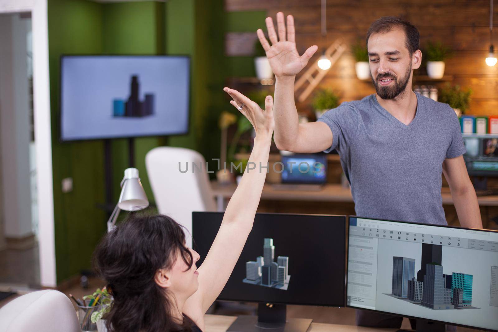 Two successful young business partners give a hi5 to each other. Collegues happy about their success.