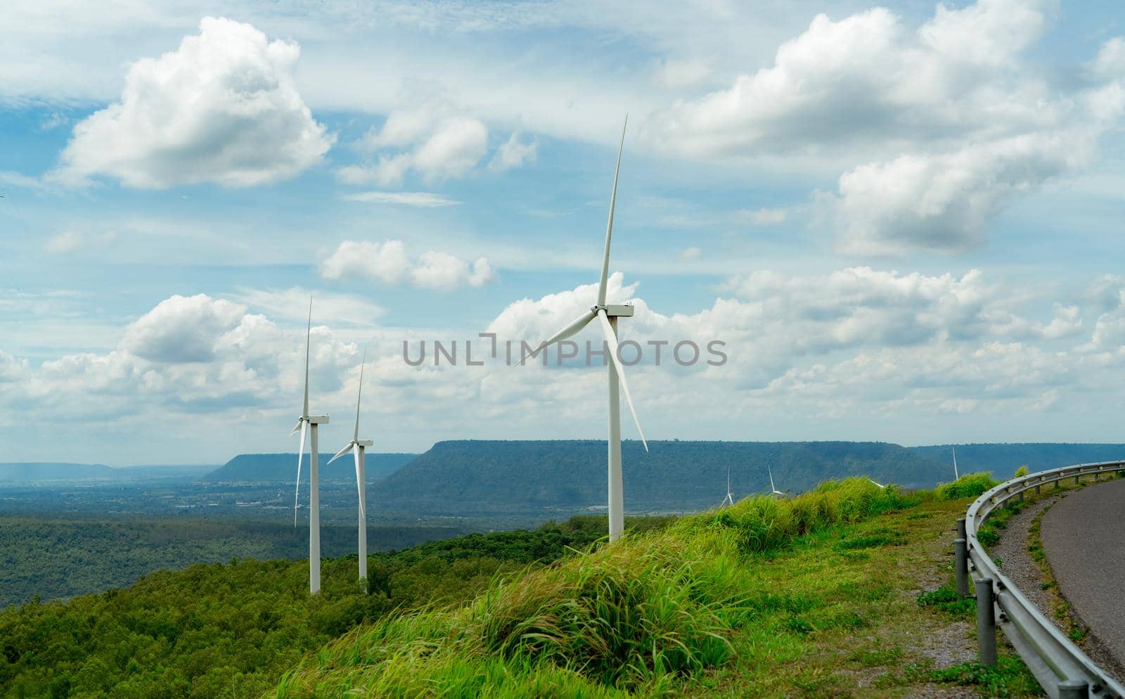 Wind energy. Wind power. Sustainable, renewable energy. Wind turbines generate electricity. Windmill farm on a mountain with blue sky. Green technology. Renewable resource. Sustainable development.