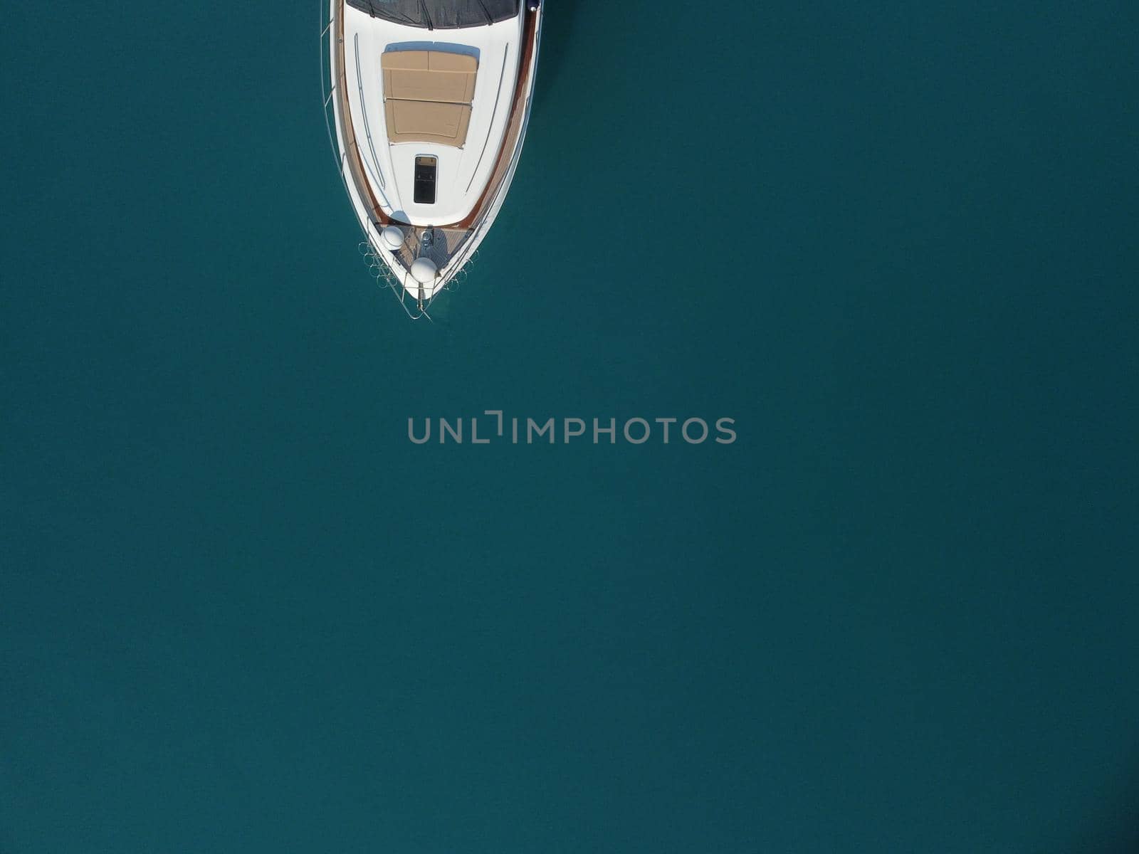Aerial boat race. Luxury cruise trip. View from above of white boat on deep blue water. Aerial view of rich yacht sailing sea. Motor boat racing wave. Summer journey on luxury ship