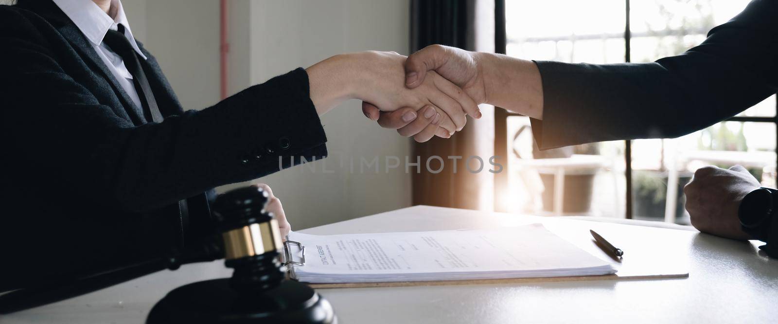 Good service cooperation of Consultation between a male lawyer and business woman customer, Handshake after good deal agreement, Law and Legal concept..