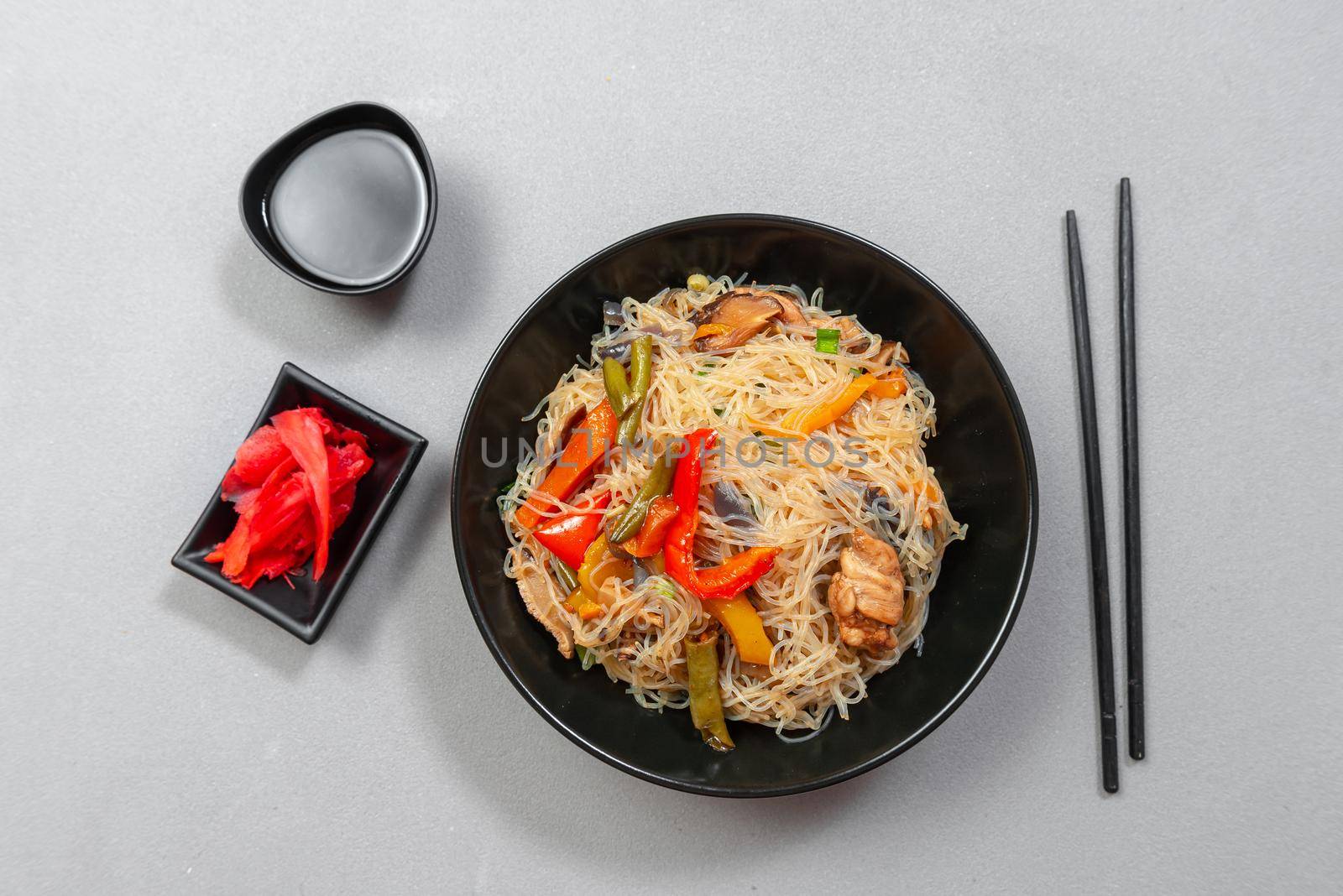 Glass noodle with vegetable in a black bowl on a grey background. Asian food Asian cuisine. Asian or Szechuan noodles