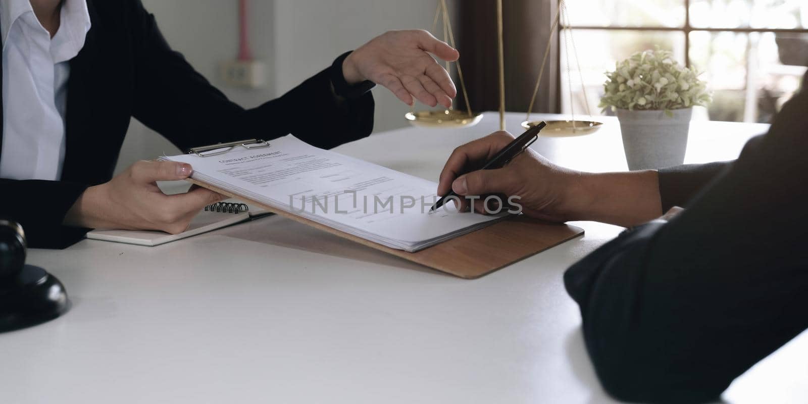 Business woman and lawyers discussing contract papers with brass scale on wooden desk in office. Law, legal services, advice, Justice concept..