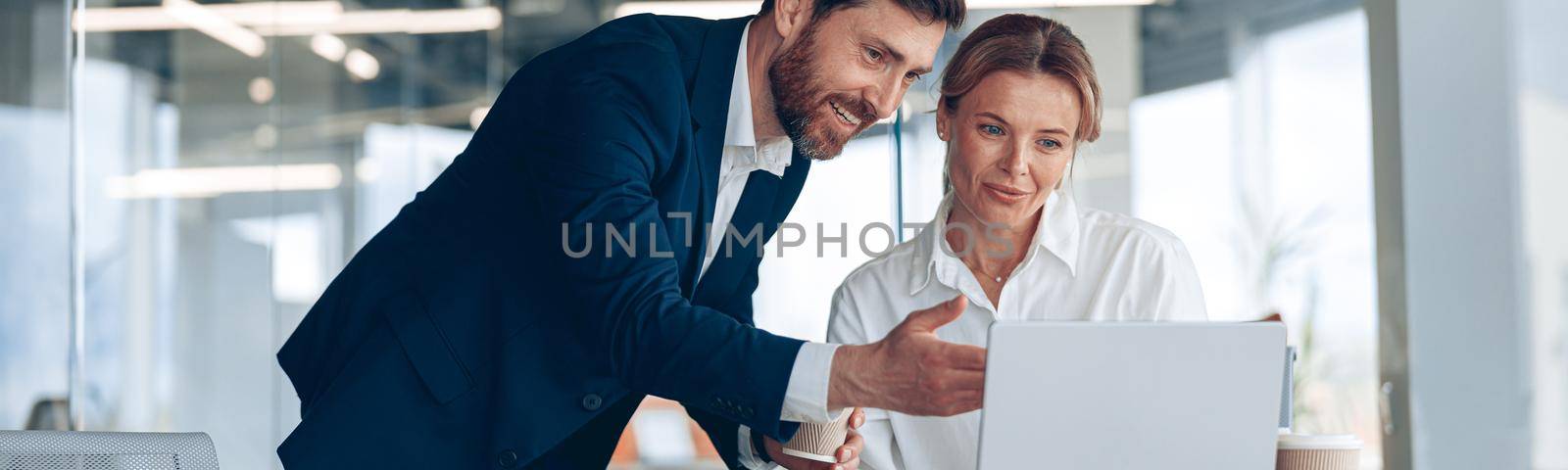 Female boss discussing online project with employee showing presentation to experienced team leader