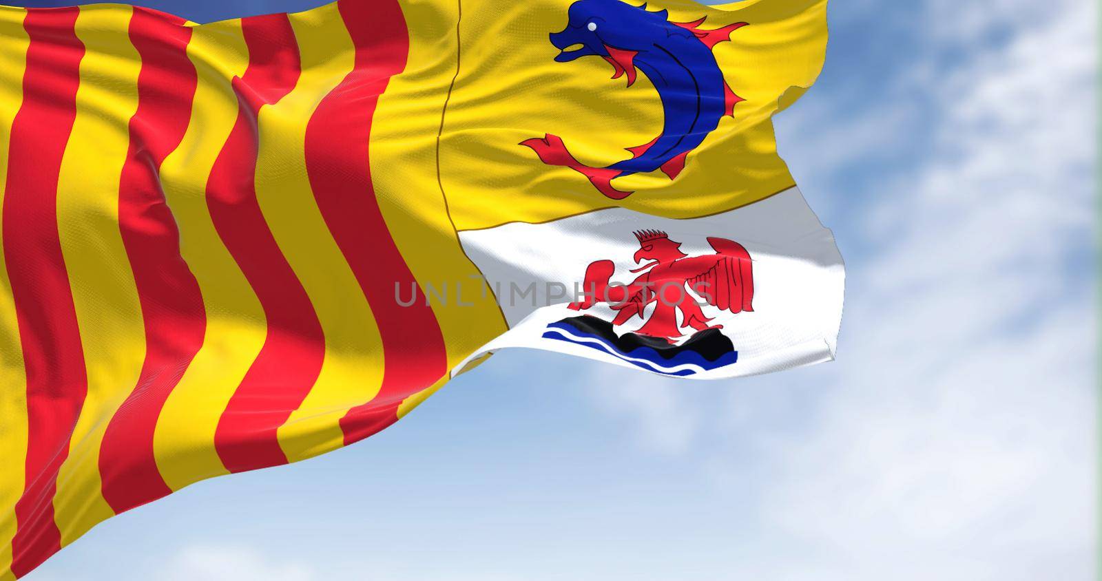 The region flag of Provence-Alpes-Côte d'Azur waving in the wind on a clear day. Provence-Alpes-Côte d'Azur is one of the eighteen administrative regions of France
