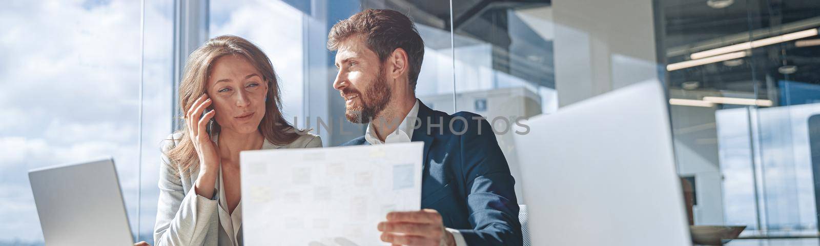 Businessmen talk phone during a meeting and discussing business looking at financial charts