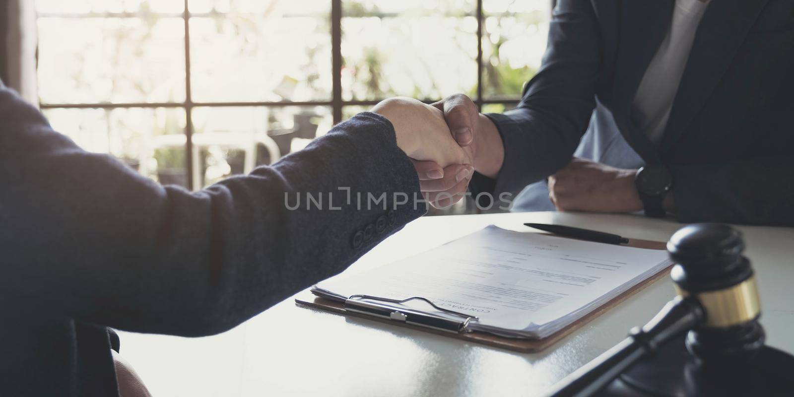 Good service cooperation of Consultation between a male lawyer and business woman customer, Handshake after good deal agreement, Law and Legal concept. by wichayada