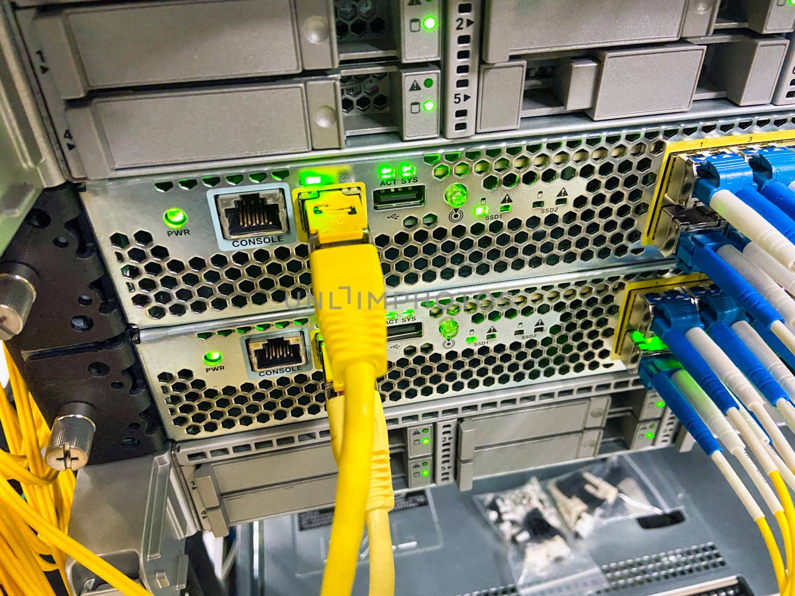 Network equipment with green lights working in a data center.
