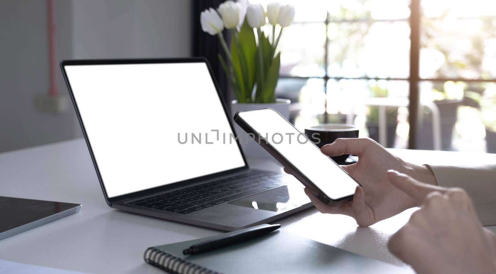 computer,cell phone mockup image blank screen with white background for advertising text,hand woman using laptop texting mobile contact business search information on desk in cafe.marketing,design by wichayada