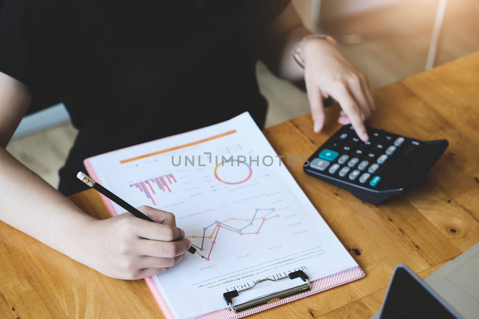 Business woman using document and using calculator to review balance sheet annual to calculating budget. for audit and Check integrity before investment by Manastrong