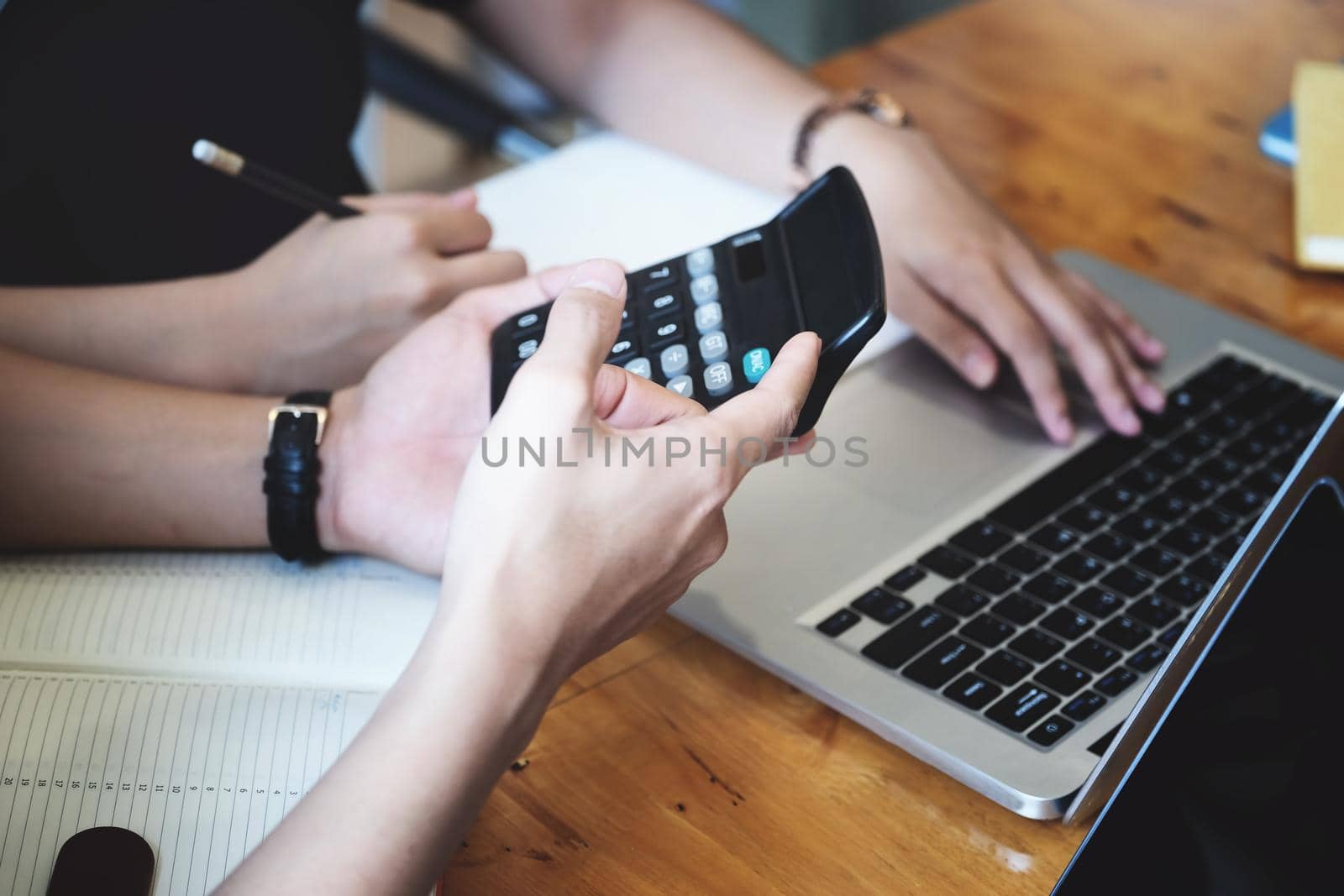 vintage tone effect with business man using calculator to calculate budget and partnership using computer at work by Manastrong