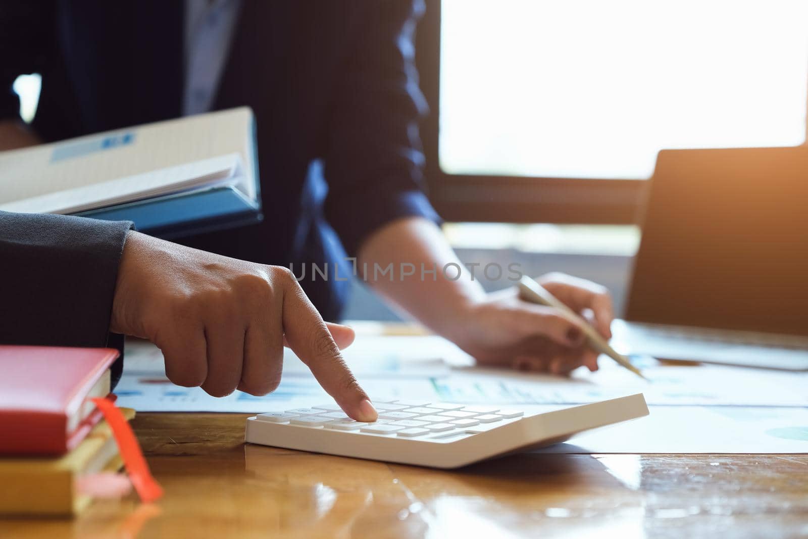 vintage tone effect with business man using calculator to calculate budget and partnership using computer at work by Manastrong