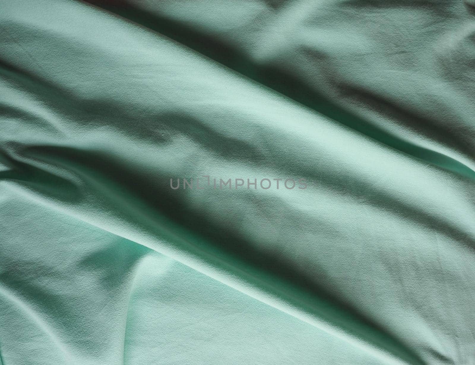 crumpled teal green fabric texture background by claudiodivizia