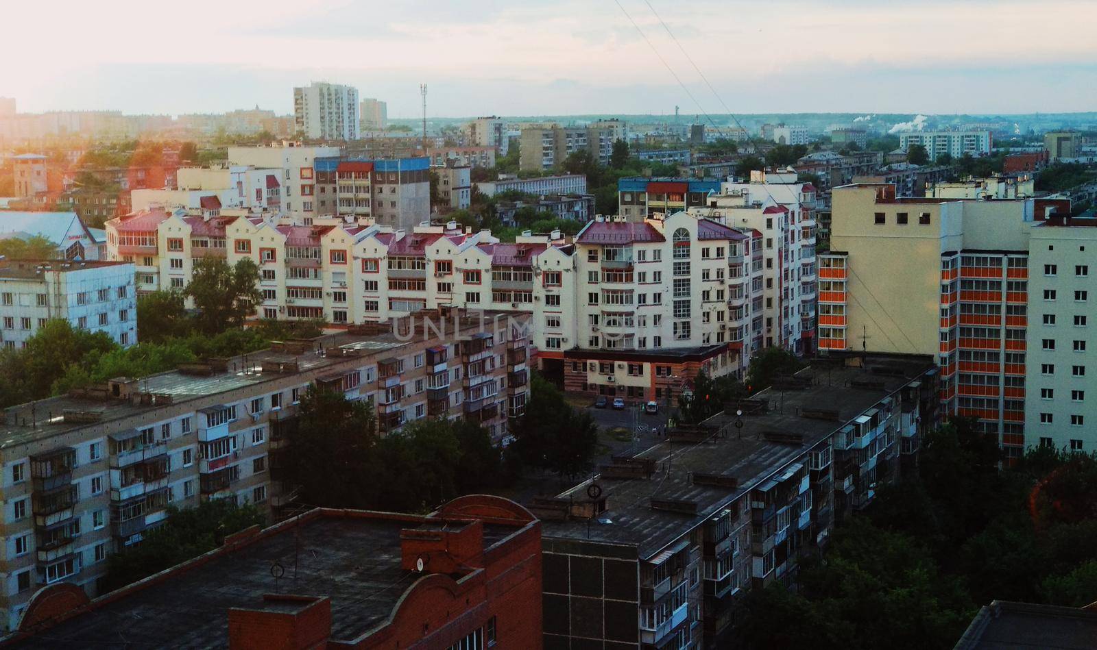 Top view of residential buildings and the evening city in the rays of the setting sun