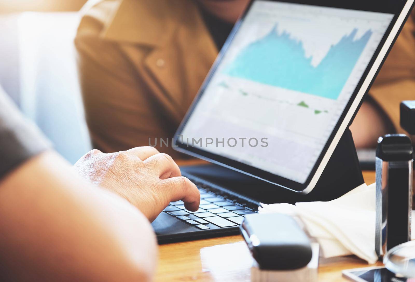 focus hands of a speculator who is using a tablet to trade stocks to make a profit on his own port. by Manastrong