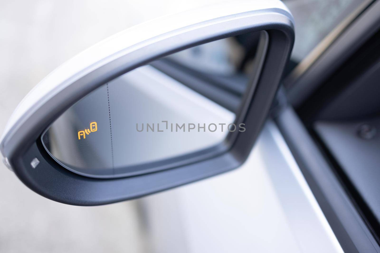 Blind zone monitoring sensor on the side mirror of a modern electric car. System blind spots of the car. Detail of side keeping assist system switch button by uflypro