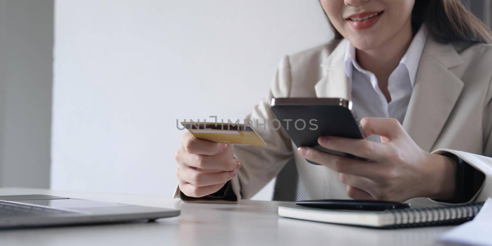 Young Asian businesswoman enjoy shopping online using credit card at a coffee shop..