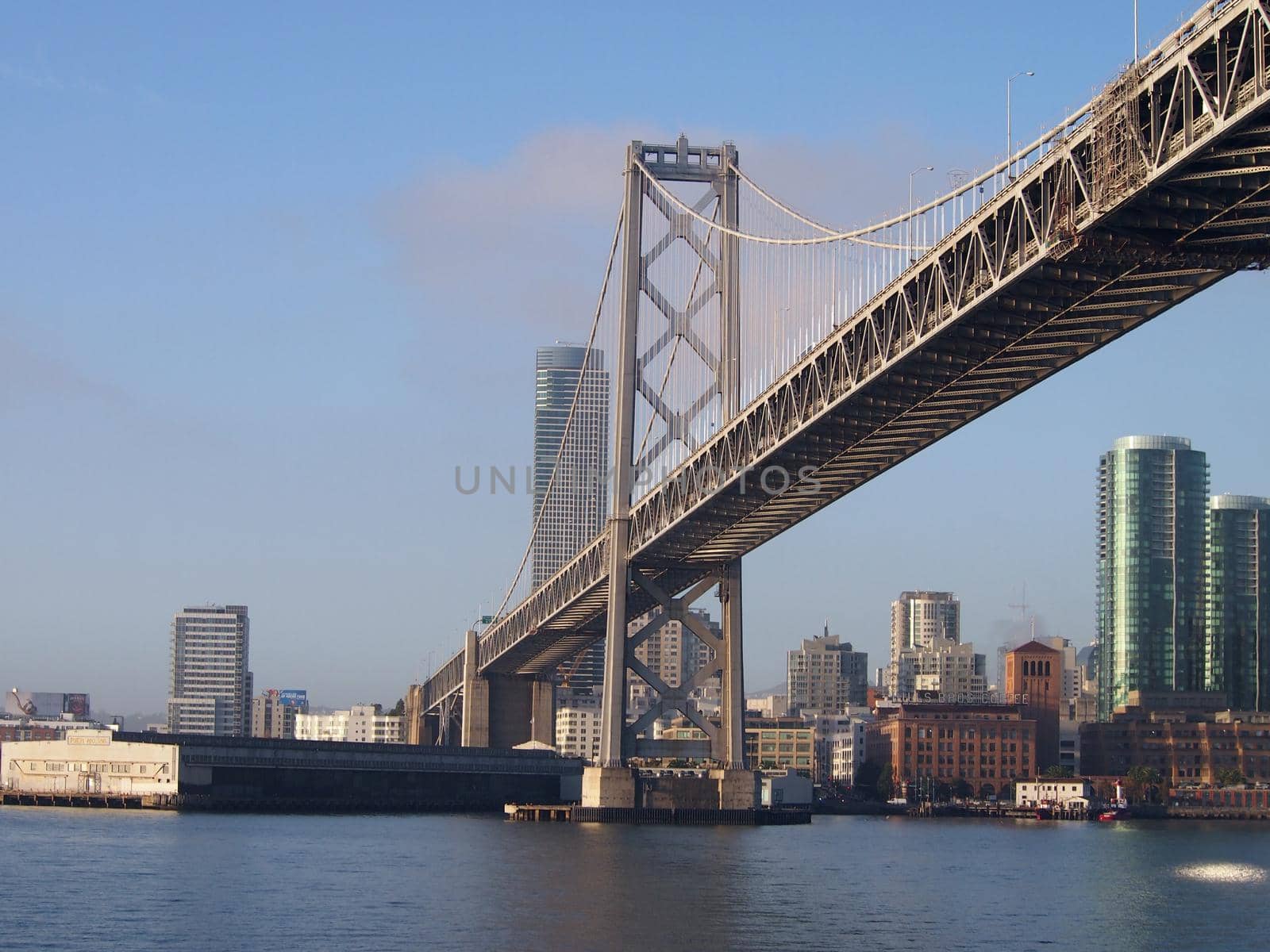 San Francisco side of Bay Bridge from ferry boat sailing underneath close to one of the support pillars. Bridge enters into San Francisco.