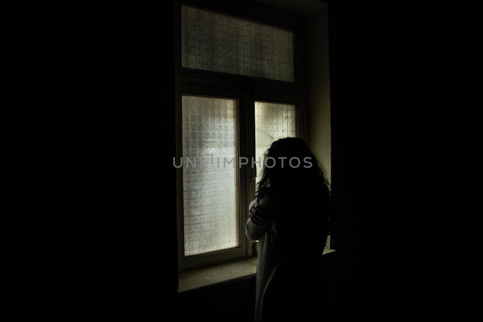 Horror woman in window wood hand hold cage scary scene halloween concept Blurred silhouette of witch. Horror theme by Zeferli