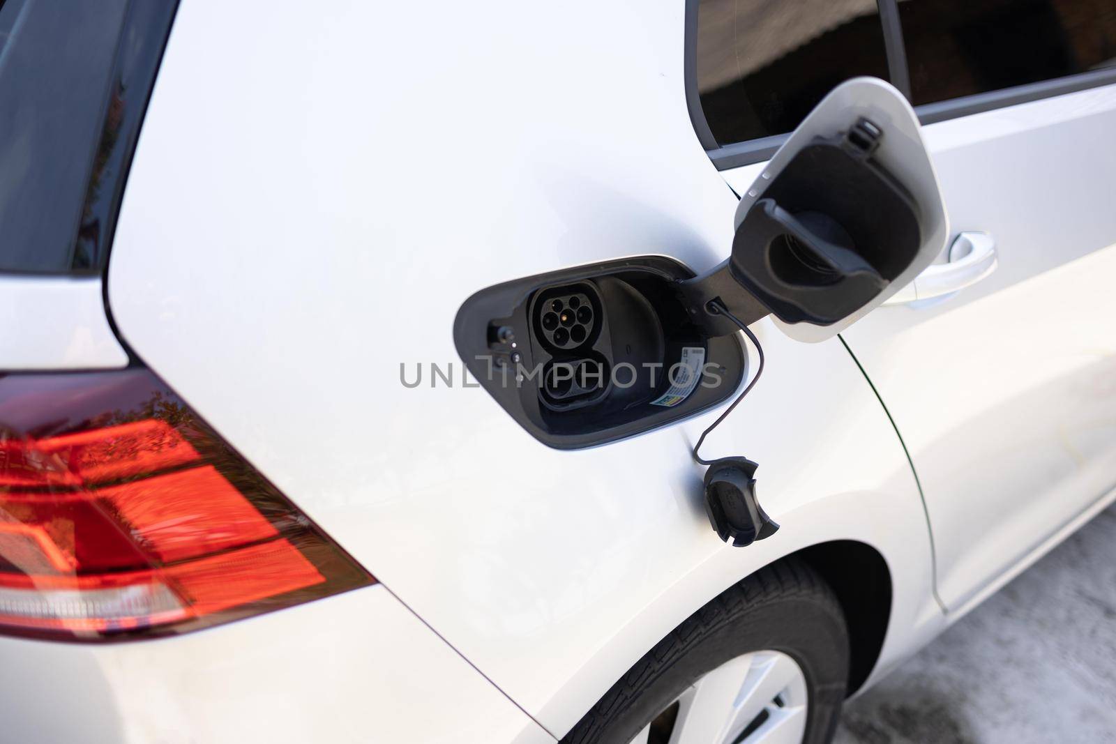 type 2 CCS plug port on electric vehicle. Fast charging socket type 2 combo electric car. DC - CCS type 2 EV charging connector at EV car. Eco friendly alternative energy green environment concept. by uflypro