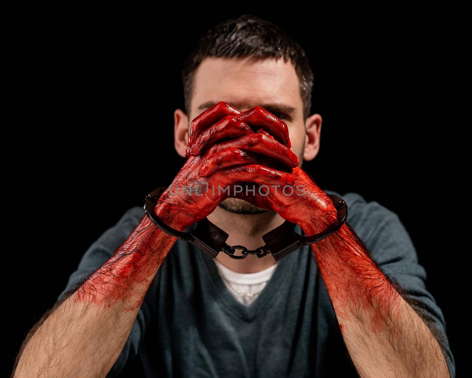 Portrait of a man with bloody hands handcuffed. by mrwed54