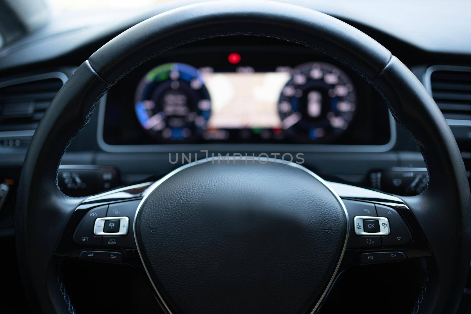 Close up of steering wheel of a new electric vehicle, interior cockpit, electric buttons, digital speedometer. Electric car control devices. Cruise control buttons, speed limitation, car's signal.