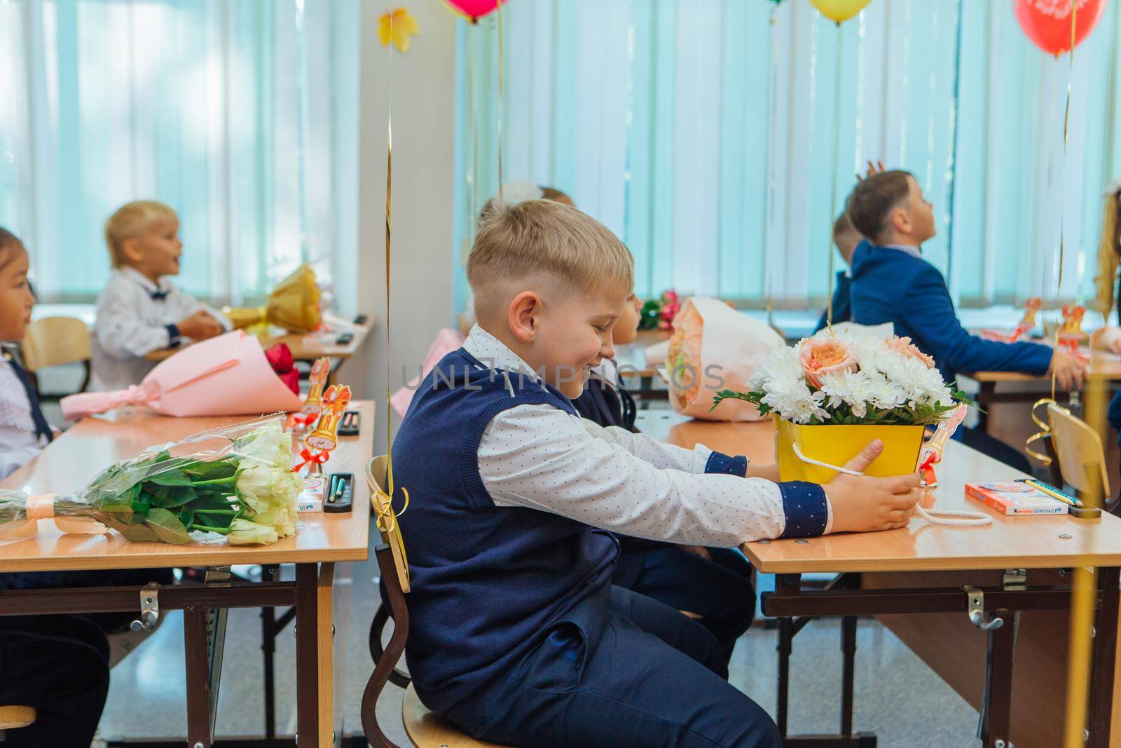 NOVOKUZNETSK, KEMEROVO REGION, RUSSIA - SEP, 1, 2021: First-grade students and teacher are in school classroom at first lesson. The day of knowledge in Russia.