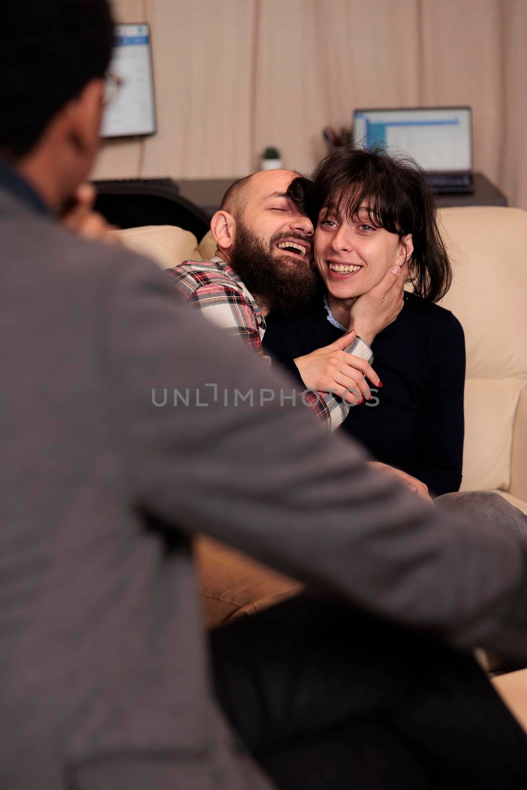 Smiling man and woman hugging and celebrating reconciliation at therapy session, feeling cheerful about solving relationship problems. Receiving professional advice and solution to save marriage.