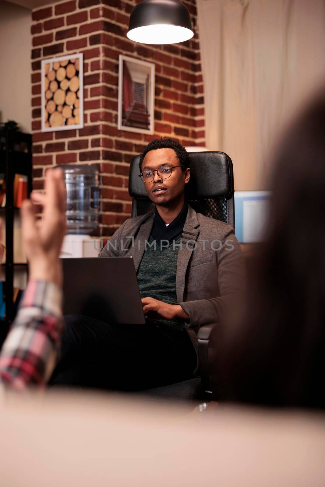 African american counselor listening to partners at couple therapy session, doing psychoanalysis on laptop. Psychology specialist helping with relationship issues and conflict.