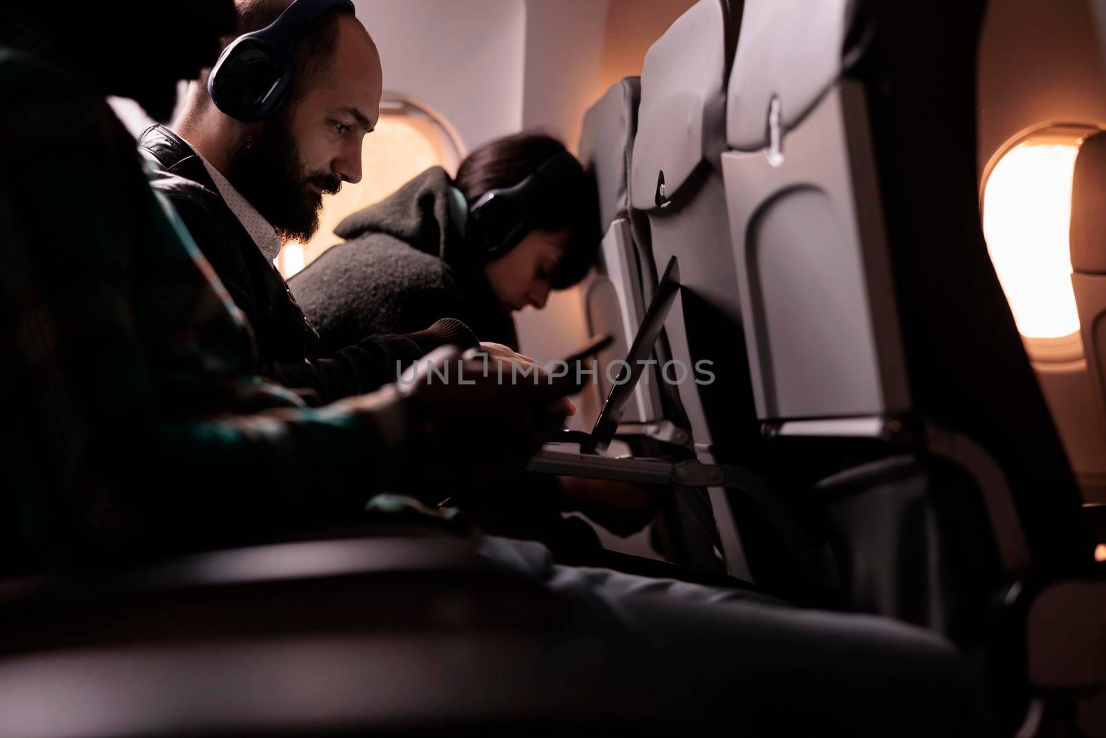 Diverse group of people travelling on commercial flight by DCStudio