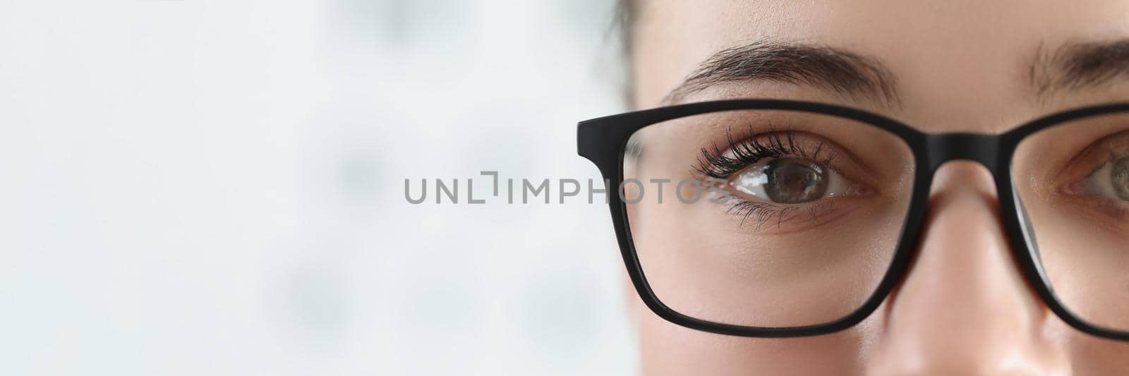 Close-up of woman face, female wear glasses for better vision with black frame. Bad sight, check eyes on oculist appointment. Optician, checkup concept