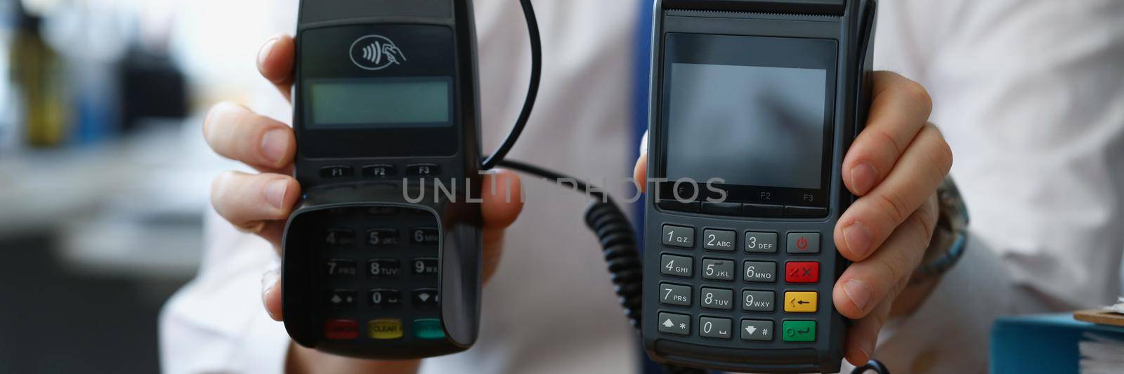 Man hold different models of credit card reader machines for cashless pay by kuprevich