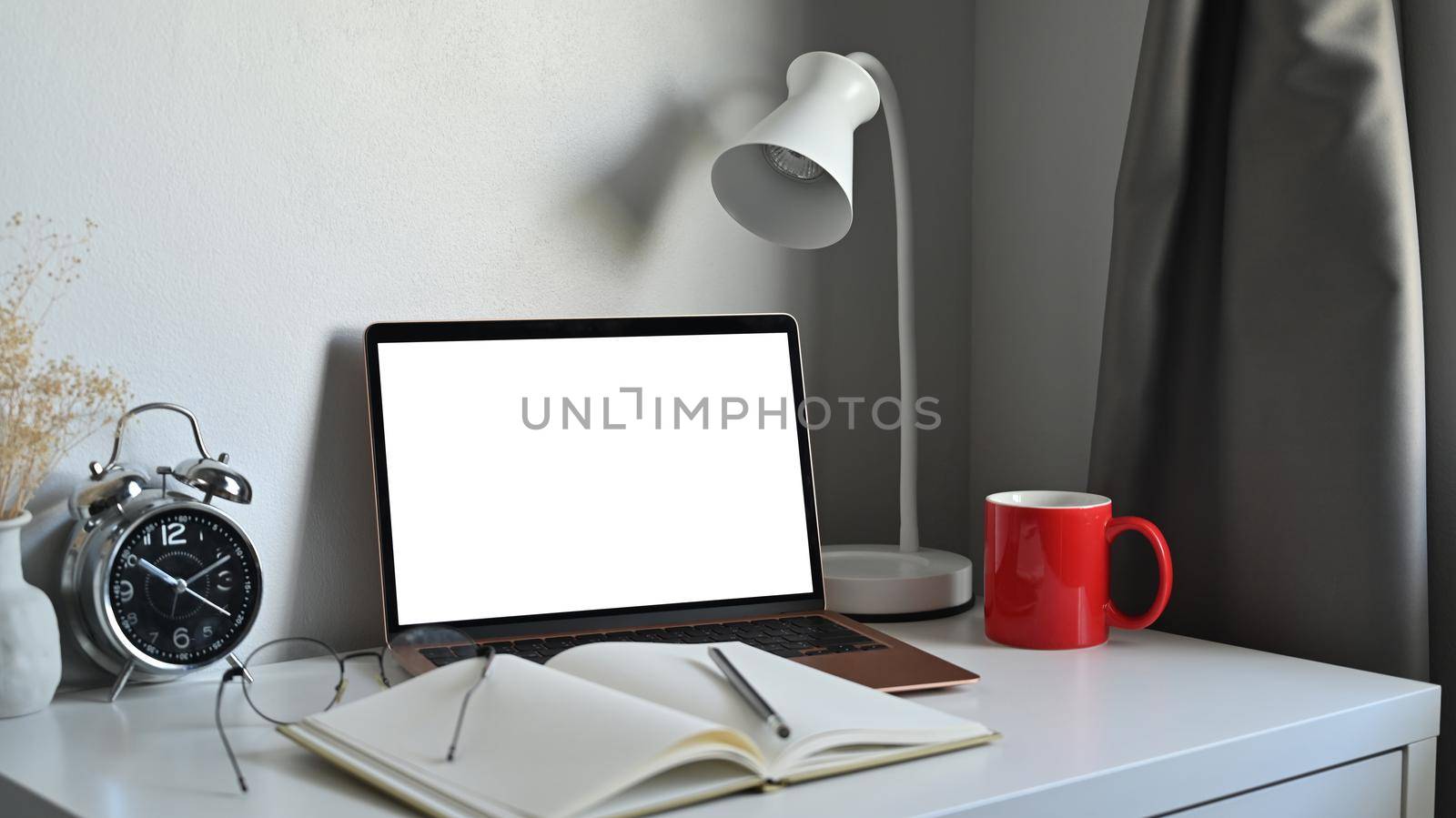 Computer laptop, notebook, coffee cup and lamp on white table. by prathanchorruangsak