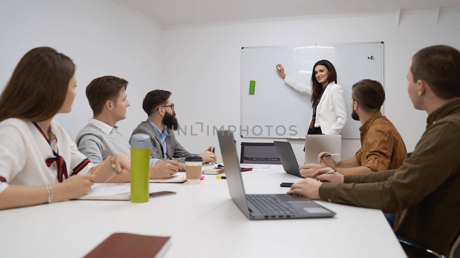 Female manager or team leader. Team and manager discussing during the meeting in IT office by berezko