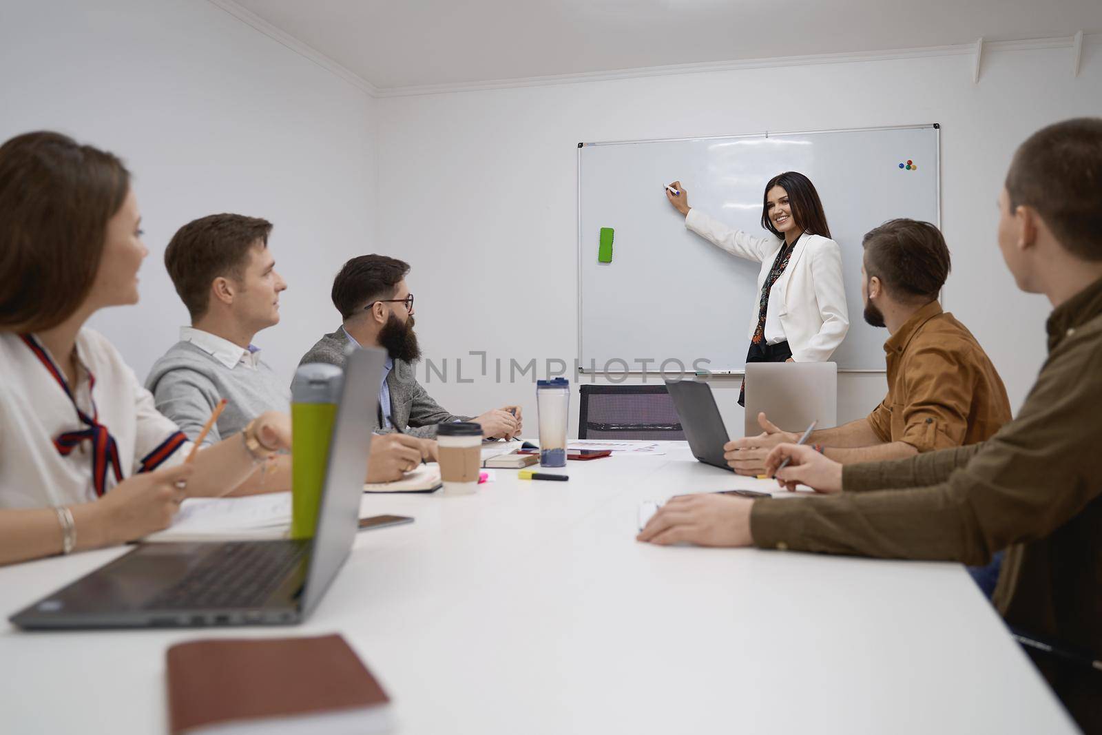Female manager or team leader. Team and manager discussing during the meeting in IT office by berezko