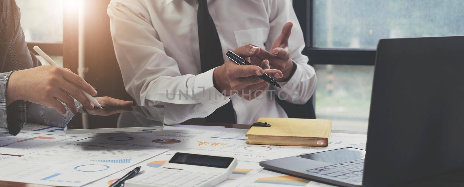 Group of business people meeting together pointing to the tablet assess business profits..