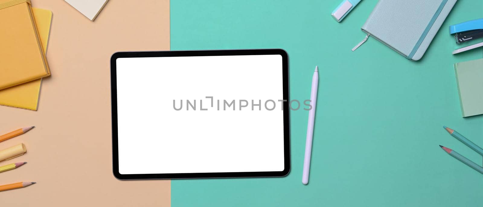 Mock up digital tablet, stylus pen and stationery on colorful background.