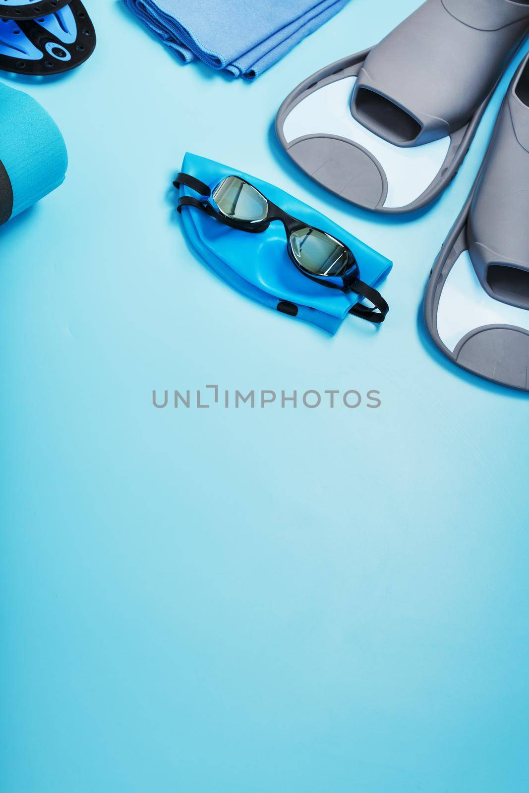 Sports equipment for swimming in the pool and open water on a blue background, close-up