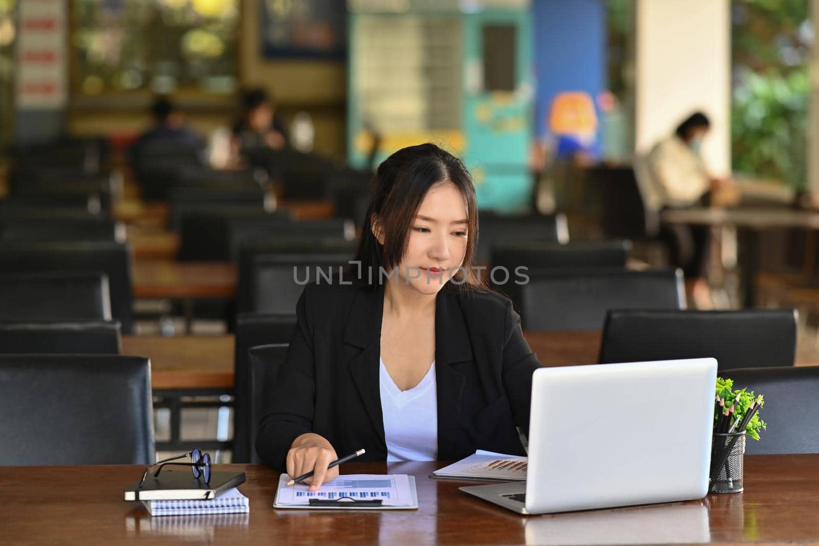 Successful asian businesswoman working with laptop computer in office. by prathanchorruangsak