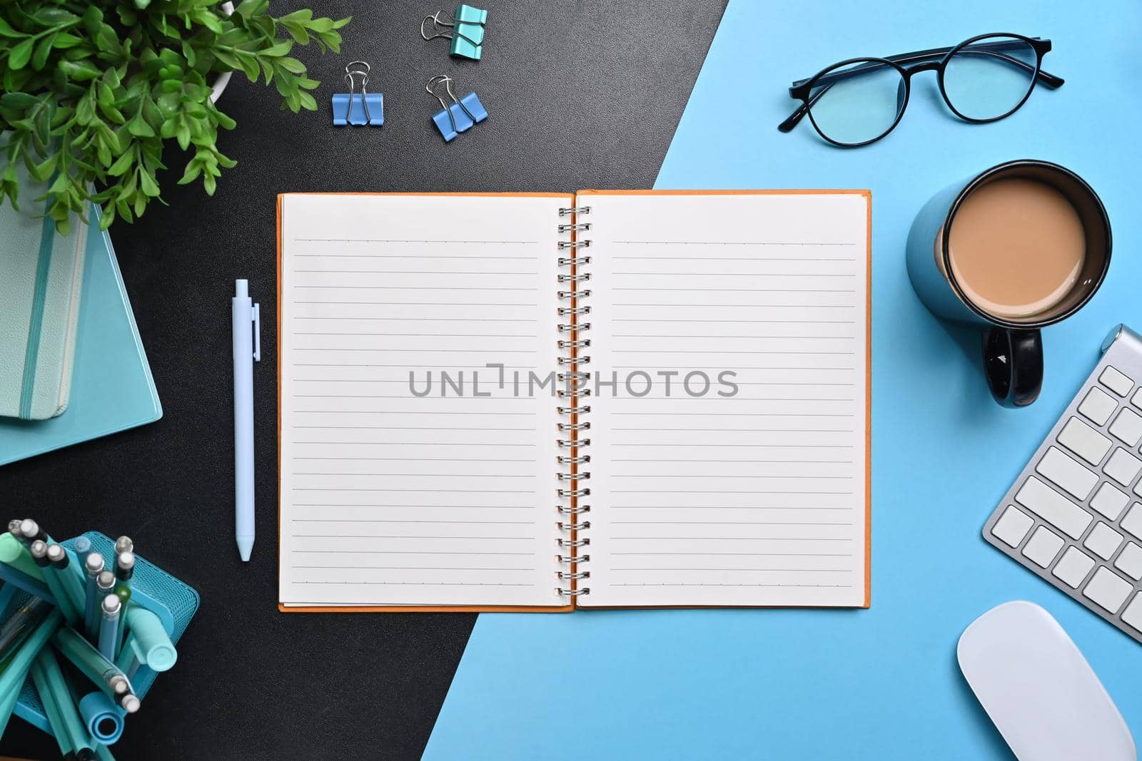 Empty notebook, glasses, stationery and coffee cup on creative workspace