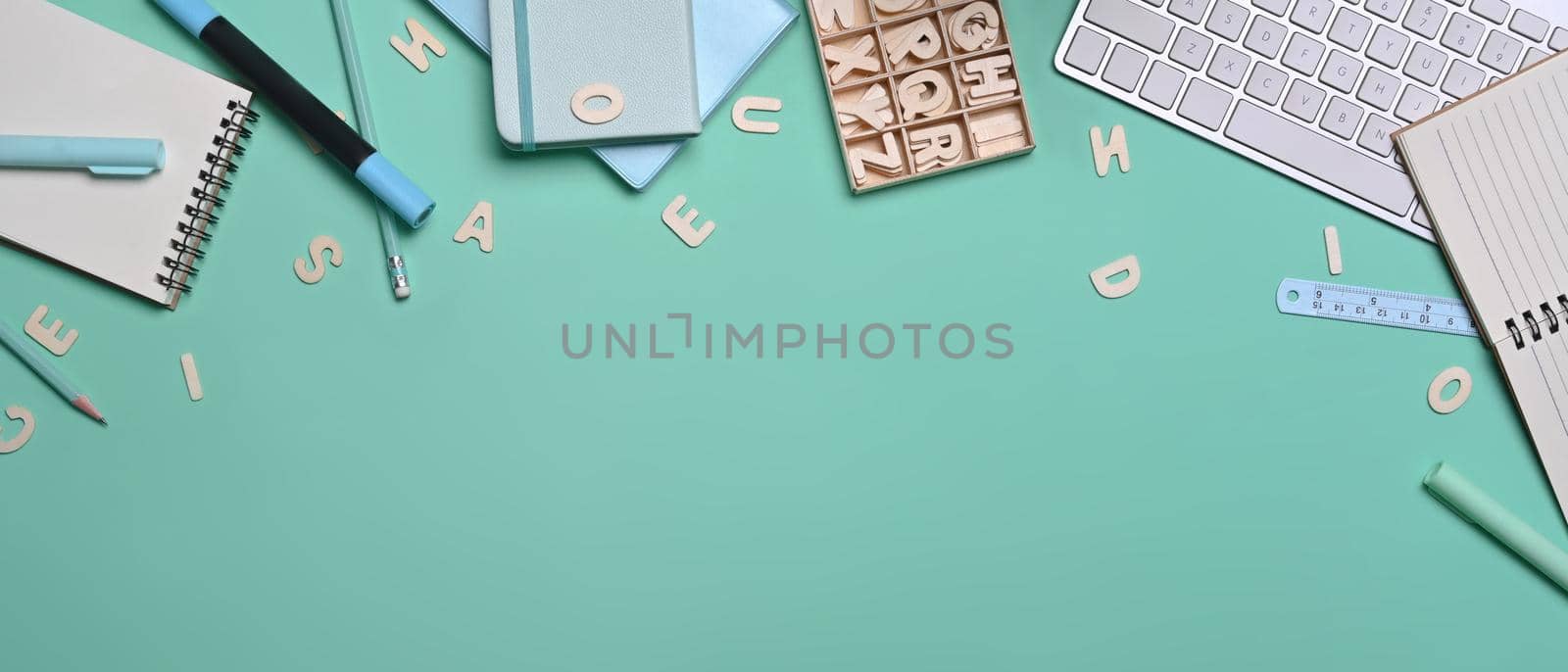 Top view various stationery and keyboard on green background. by prathanchorruangsak