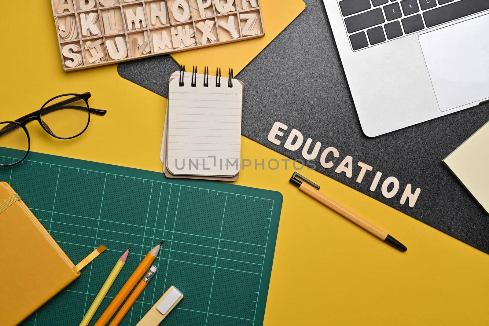 Above view laptop computer, glasses and stationery on yellow background. Back to school concept. by prathanchorruangsak