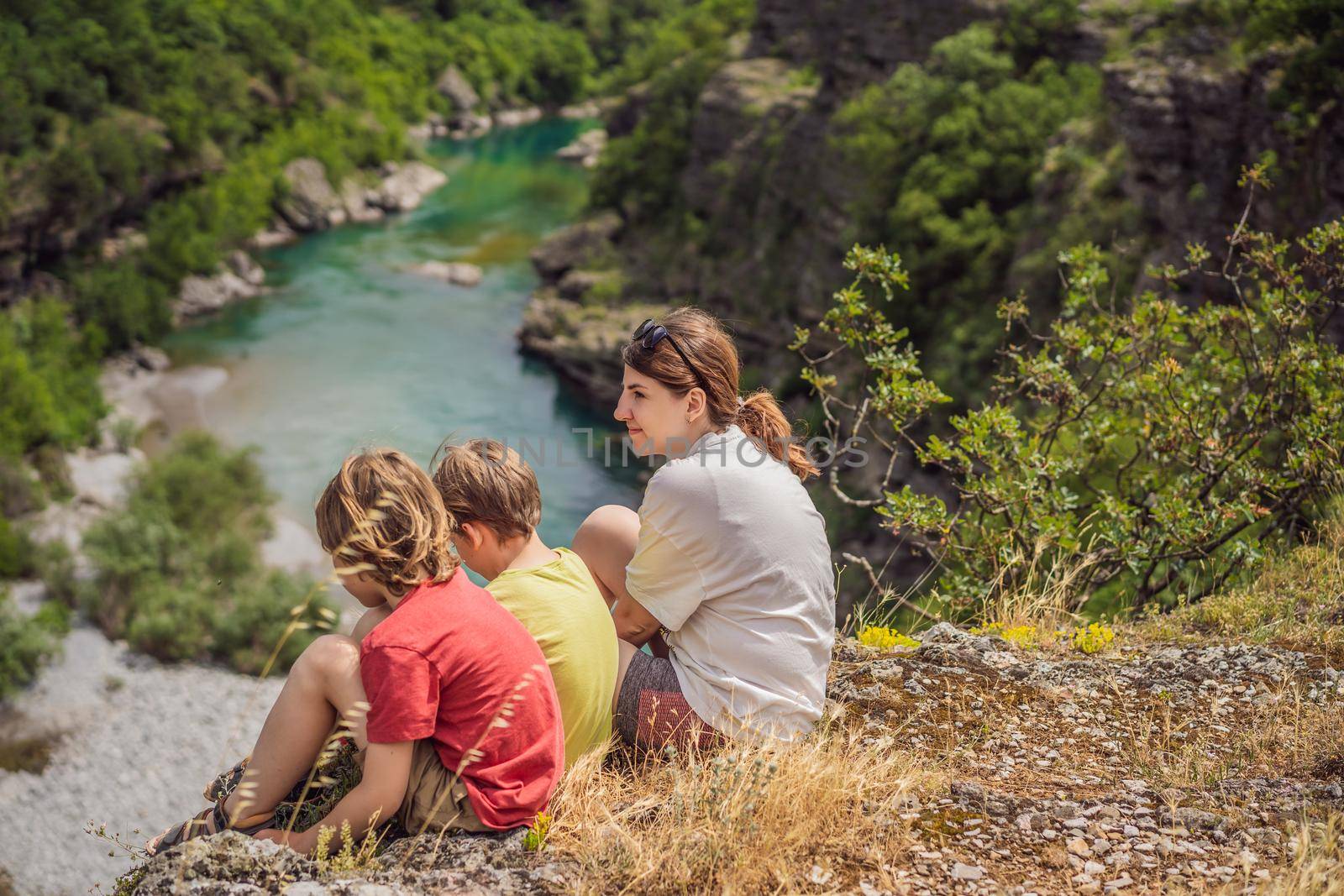 Friends tourists on background of purest waters of the turquoise color of the river Moraca flowing among the canyons. Travel around Montenegro concept.