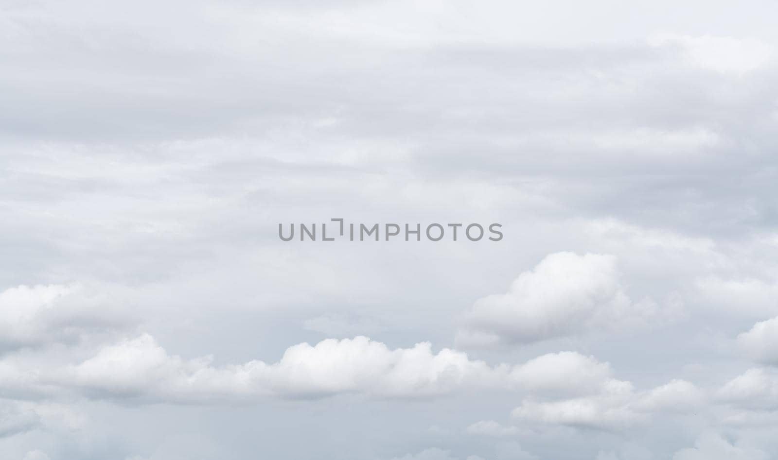 White cumulus clouds on gray sky texture background. Full frame of cloudscape background. Cloudy sky. Beauty in nature. White fluffy clouds. Nature weather. Soft texture like cotton of white clouds.