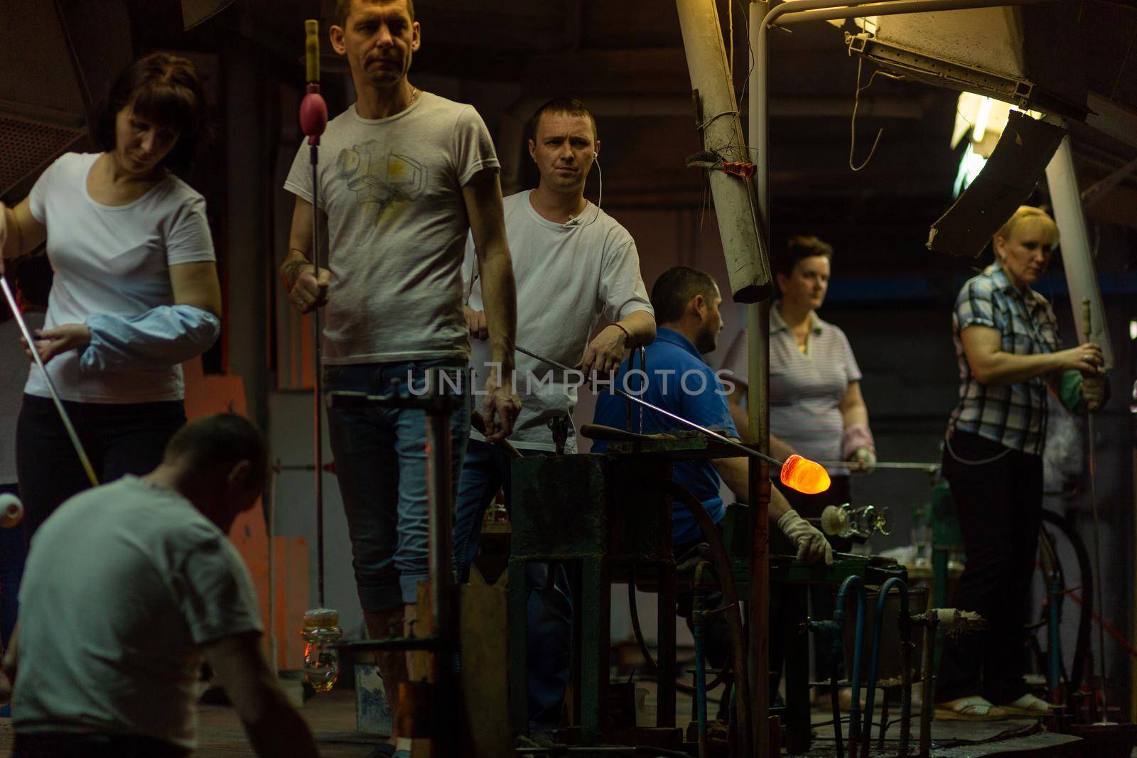 Beryozauka, Belarus - March 07, 2022: A team of glass blowers is working on the manufacture of glass vases and glasses. Up to 20 workers can be involved simultaneously in the production of particularly complex products.