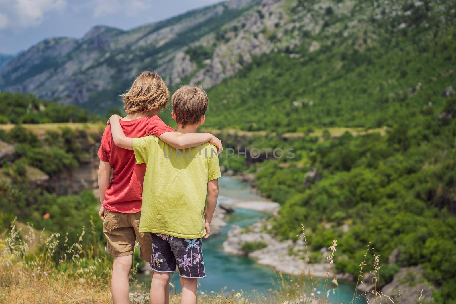 boys, friends tourists on background of purest waters of the turquoise color of the river Moraca flowing among the canyons. Travel around Montenegro concept by galitskaya