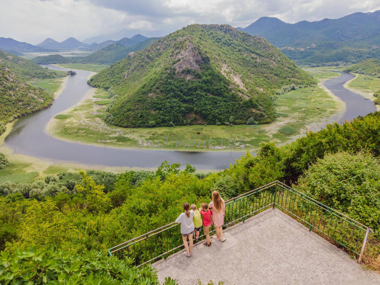 Tourists in the background Canyon of Rijeka Crnojevica river near the Skadar lake coast. One of the most famous views of Montenegro. River makes a turn between the mountains and flows backward by galitskaya